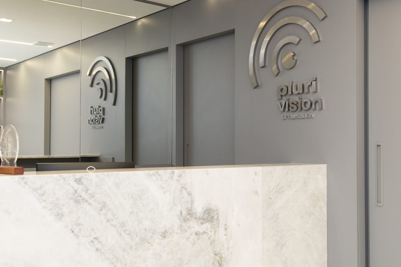 Recepção da clínica Plurivision com a placa da marca